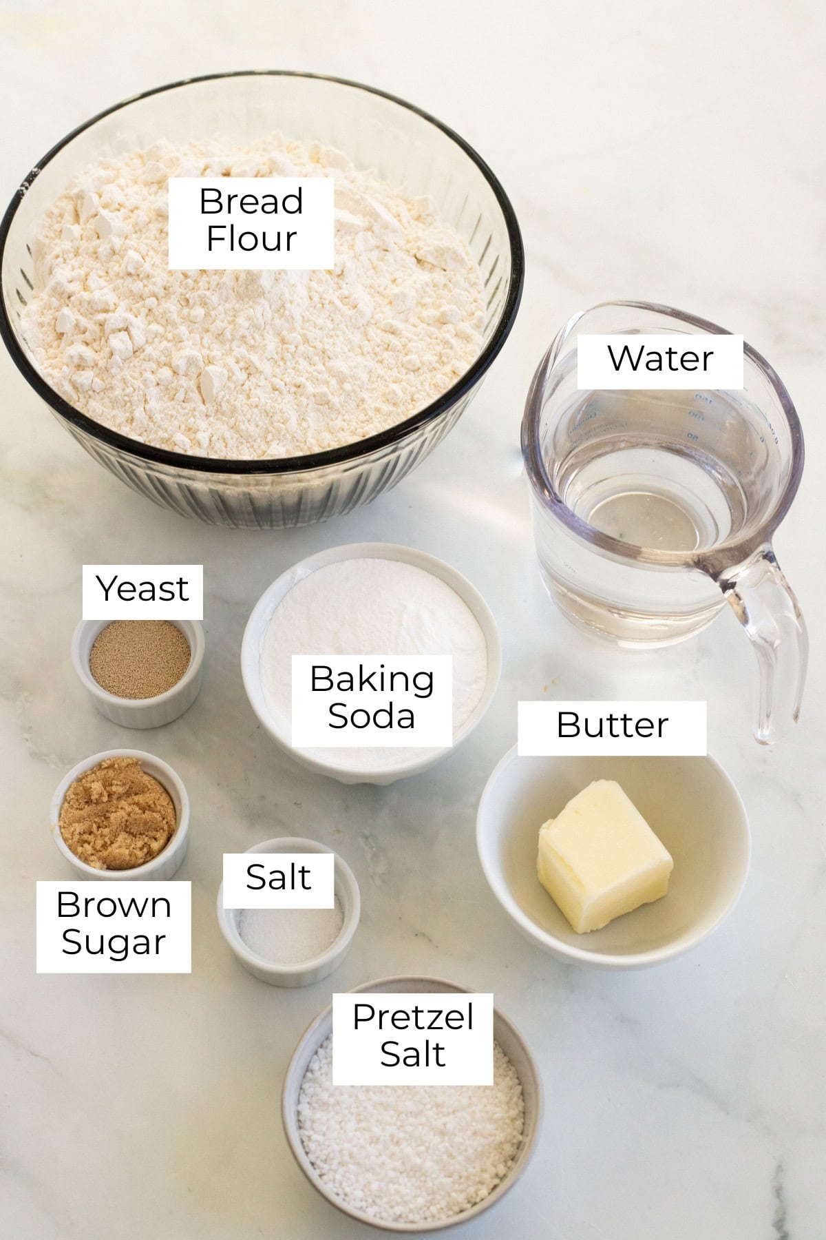 Ingredients for homemade soft pretzels labeled and laid out.