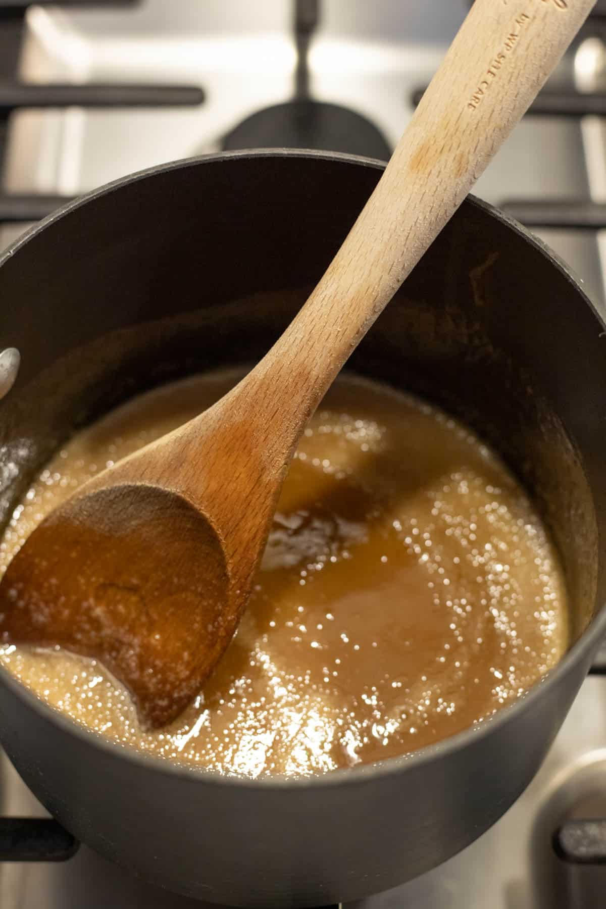 Caramel sauce boiling in a saucepan.