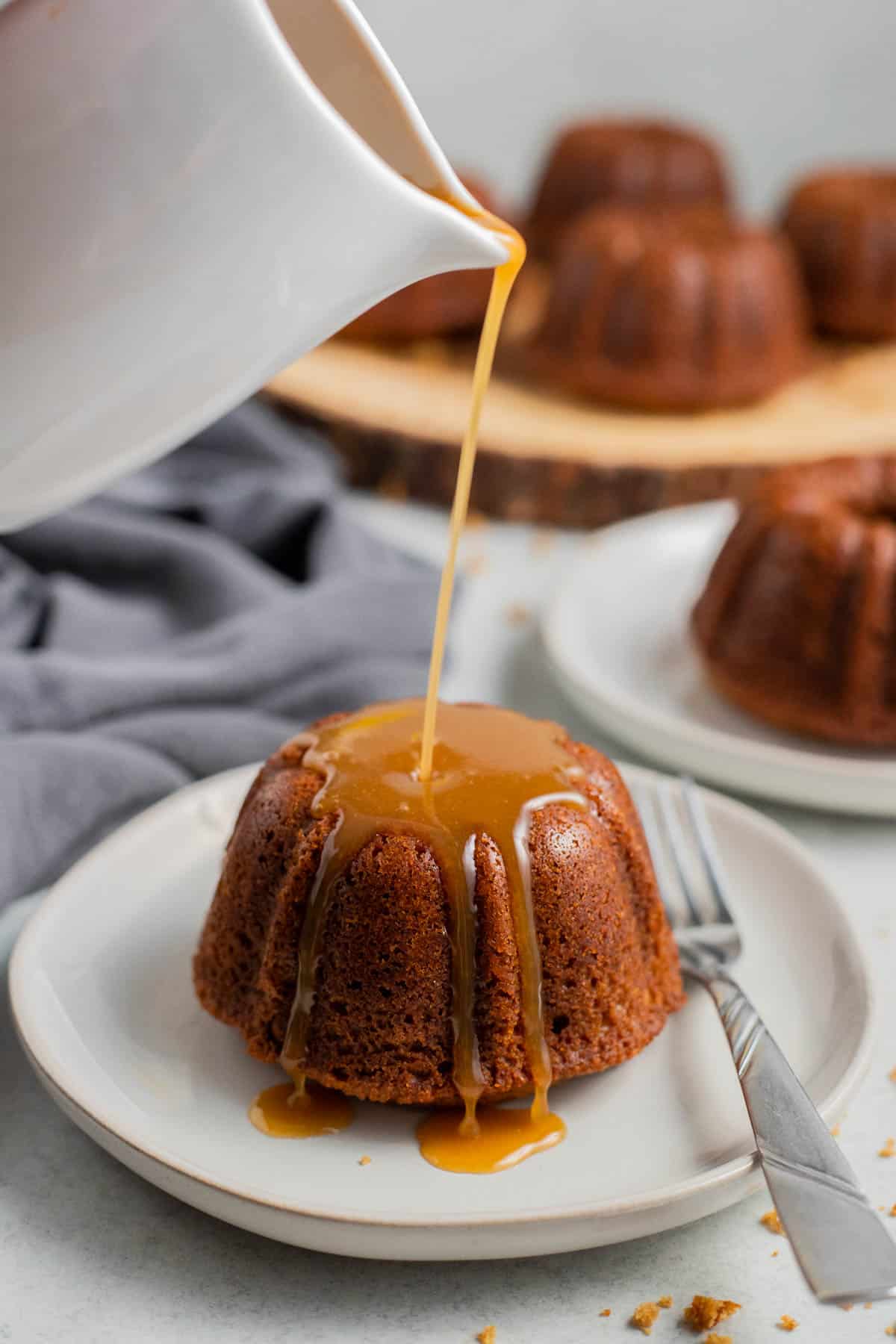 Caramel sauce pouring on top of a pudding.