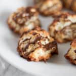 A plate of chocolate drizzled coconut macaroons.
