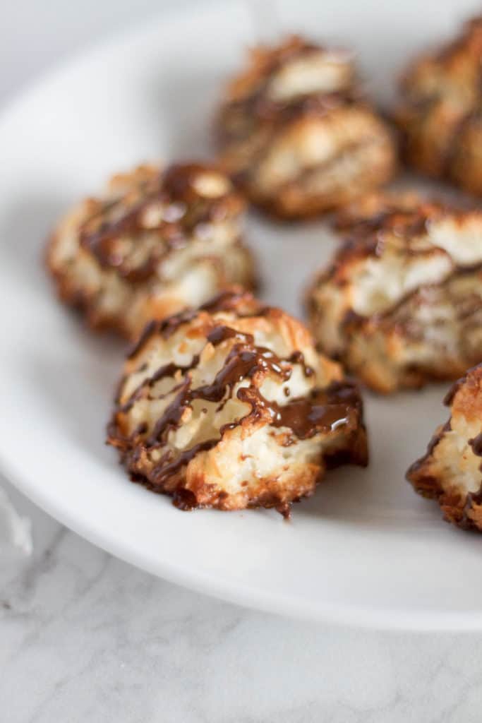 A plate of chocolate drizzled coconut macaroons.