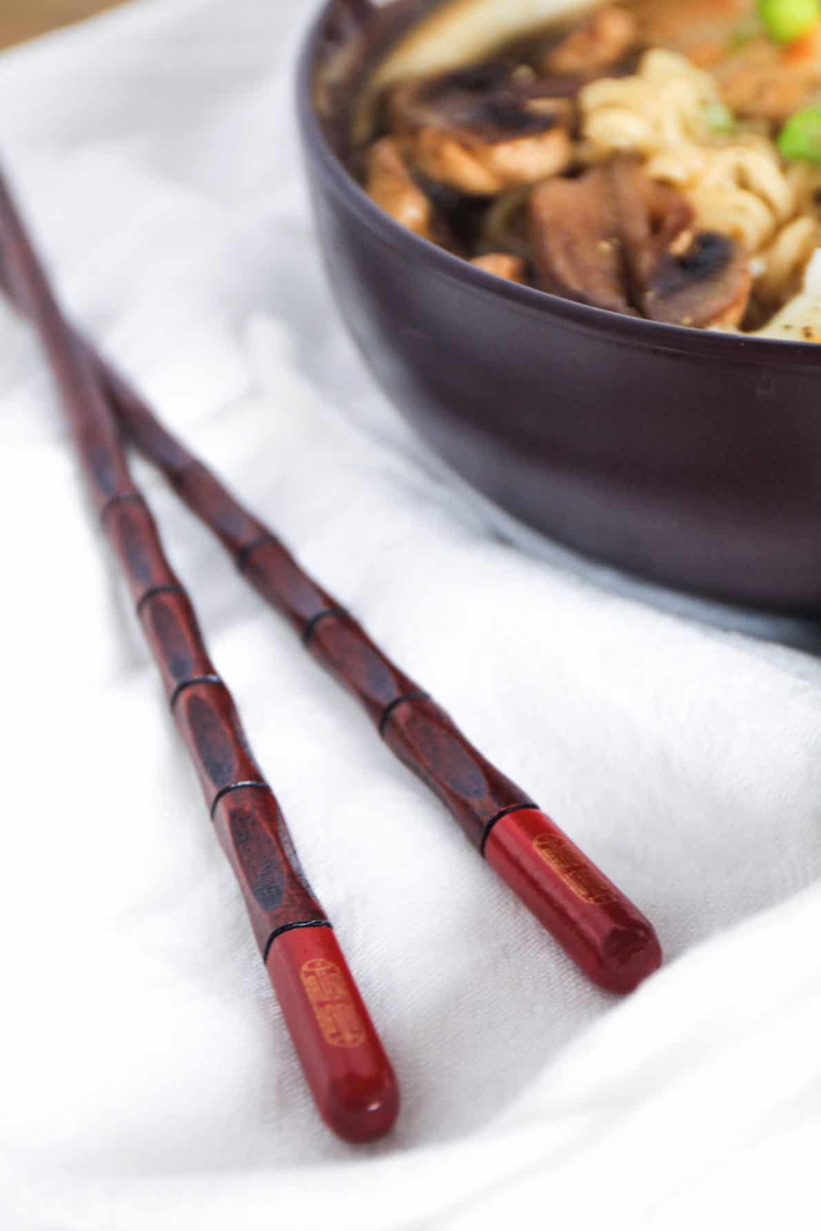 Beautiful Japanese chopsticks next to a bowl of Japanese ramen.