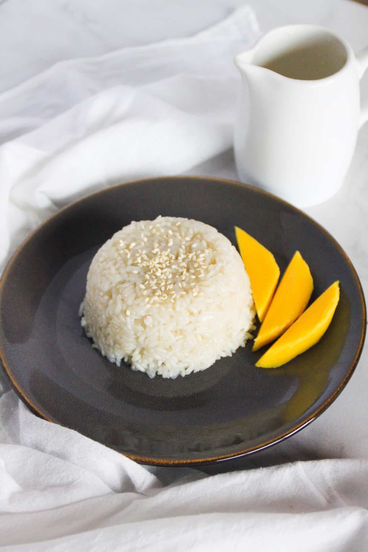 Thai Mango Sticky Rice placed on a gray plate on a white marble surface.