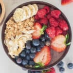 Acai bowl topped with berries, granola and coconut.