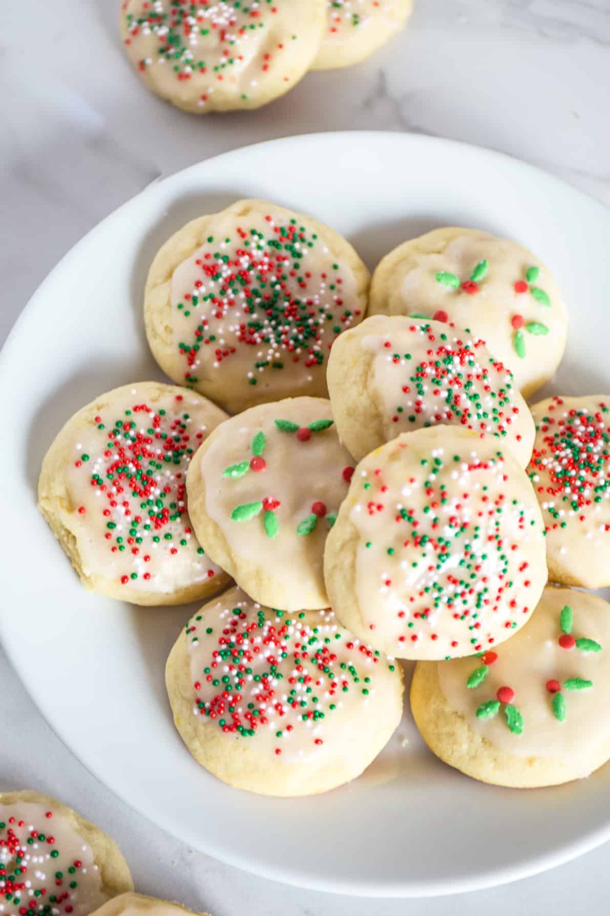 Italian ricotta cookies laid on a white plate.
