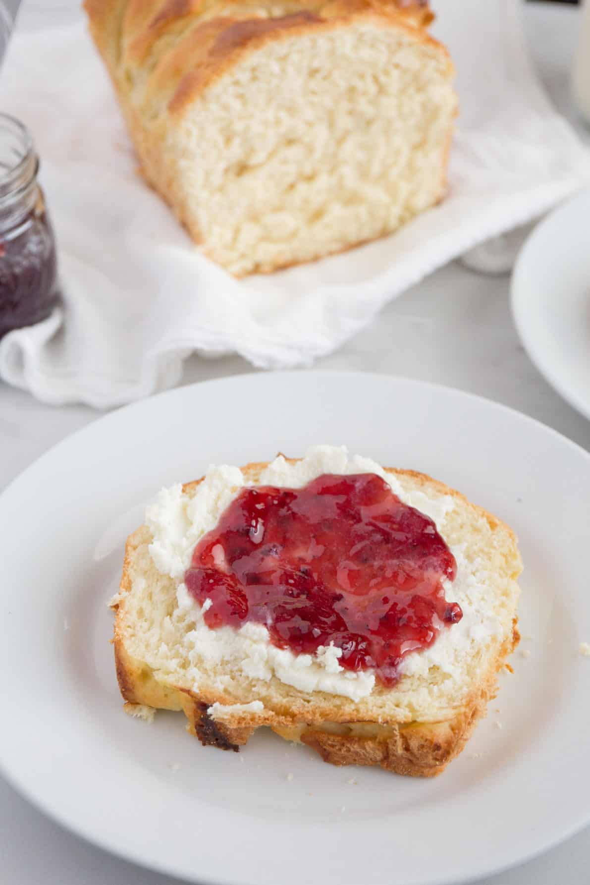 Slice of Brioche Bread topped with ricotta and jam.