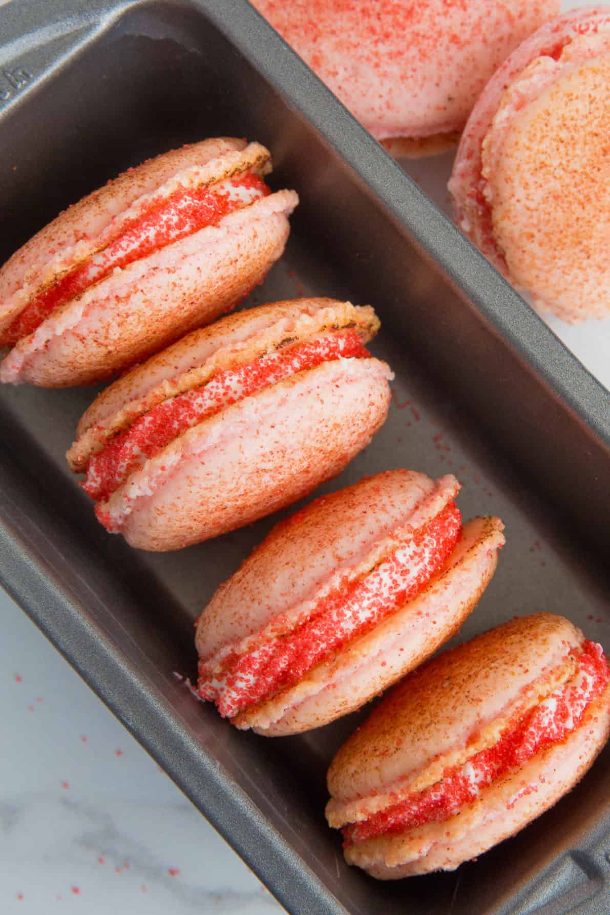 Strawberry cheesecake macarons in a pan.