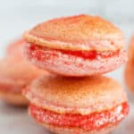 Strawberry cheesecake macarons in a stack.