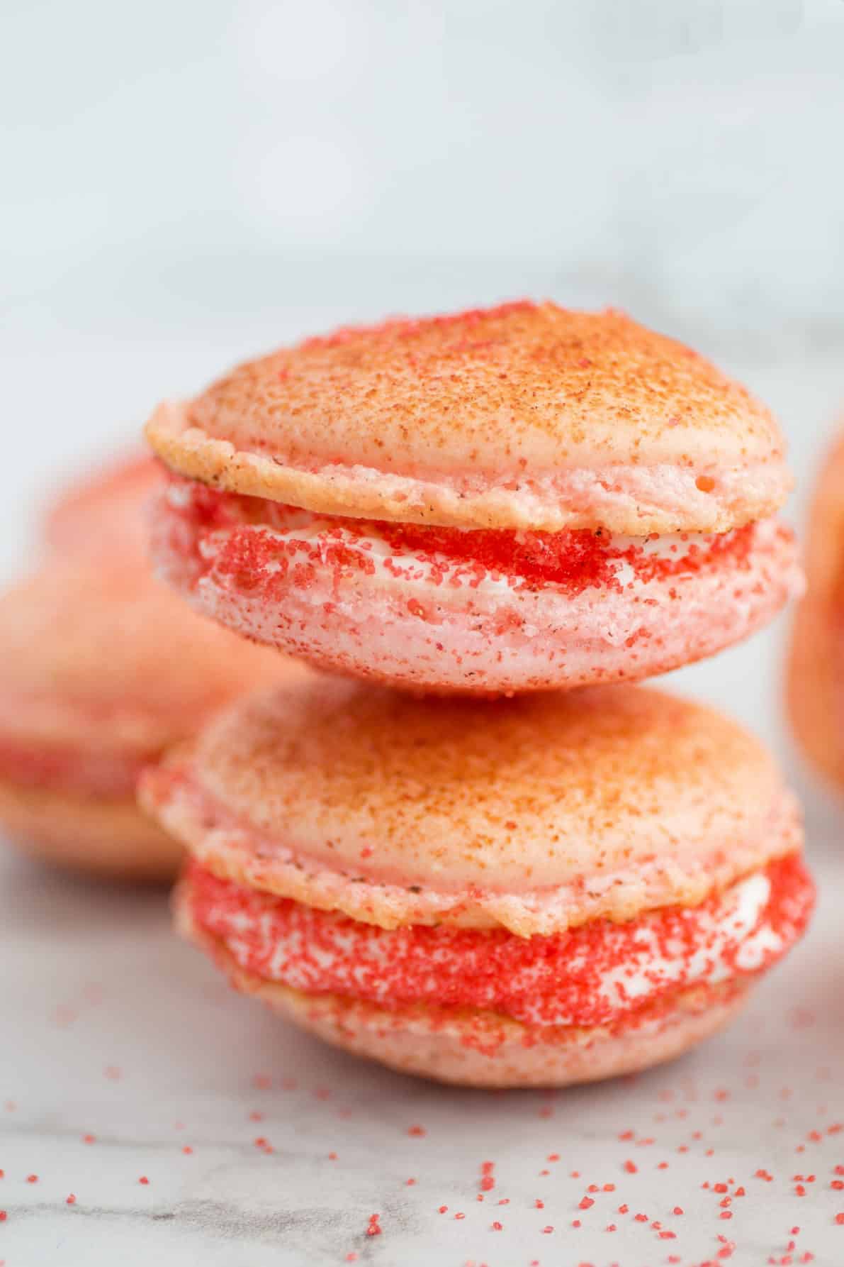Strawberry cheesecake macarons in a stack.