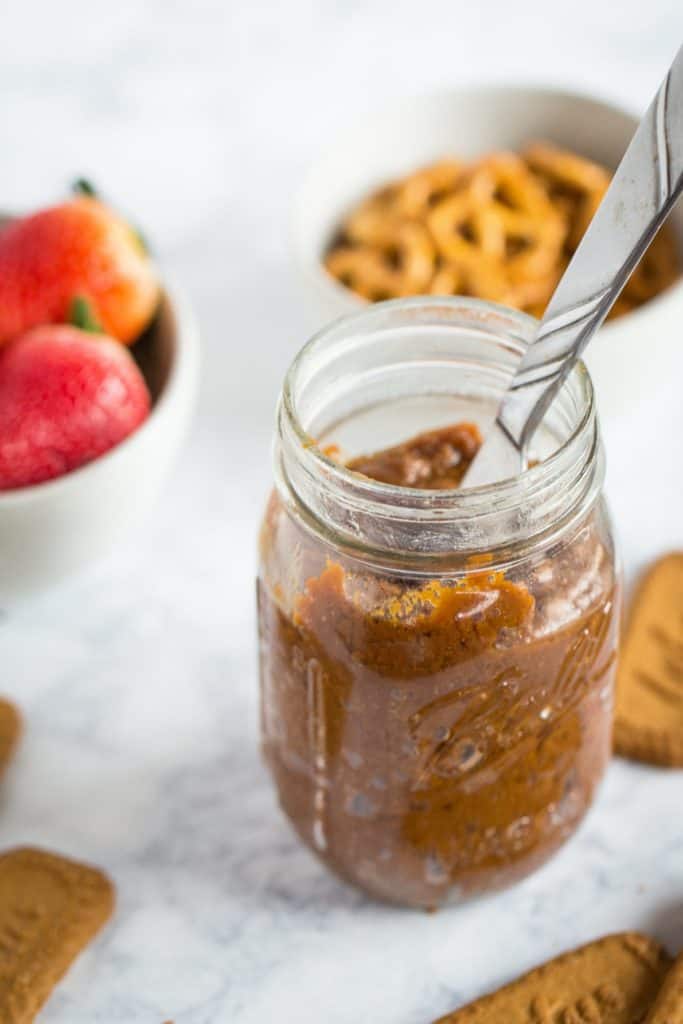 Jar of cookie butter with dippers in the background.