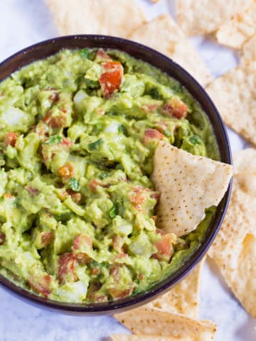 A bowl of authentic guacamole with chips.