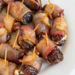 A plate full of bacon wrapped dates with cream cheese.