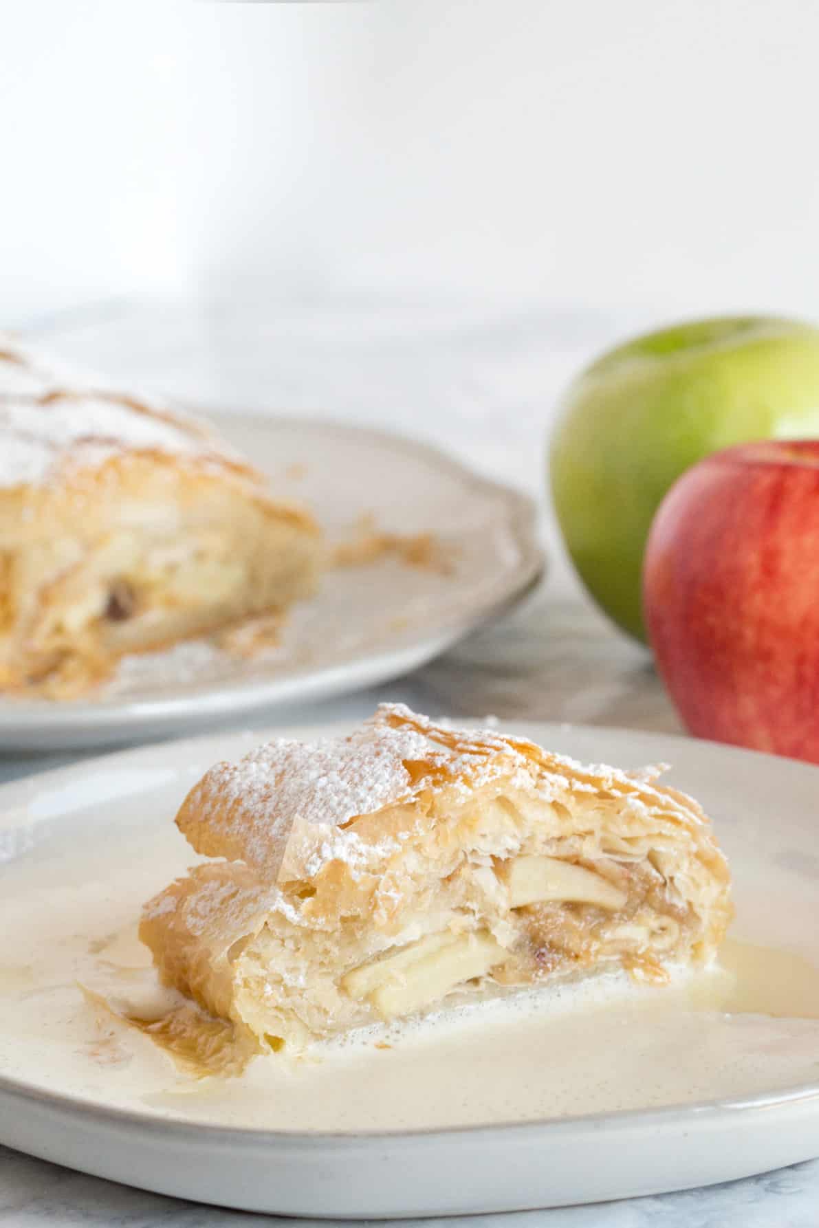 A slice of apple strudel on a white plate.