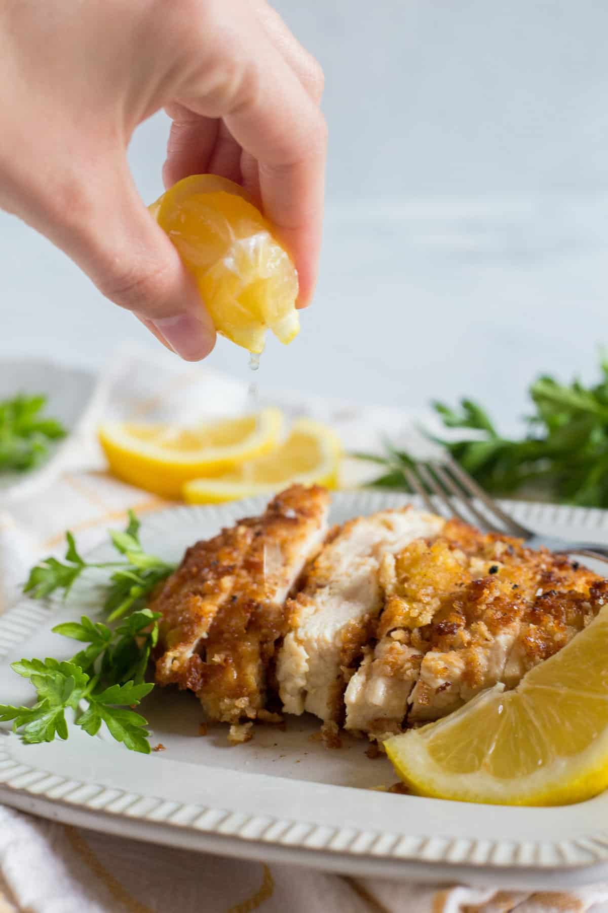 Squeezing a lemon on the chicken schnitzel.