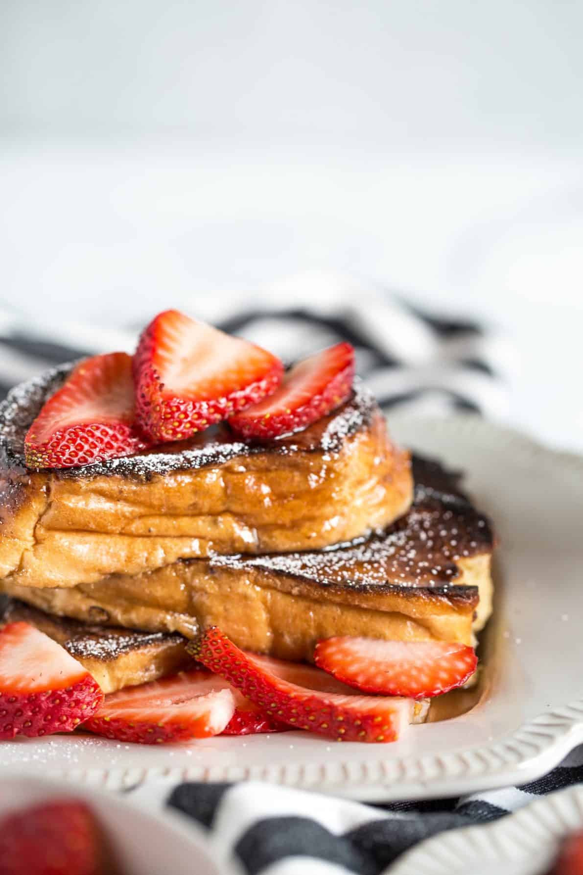 Creme Brulee French Toast on a plate with strawberries.