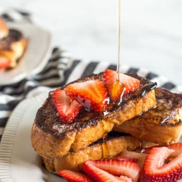 Creme Brulee French Toast on a plate with strawberries.