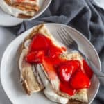 Strawberry crepes on a white plate.