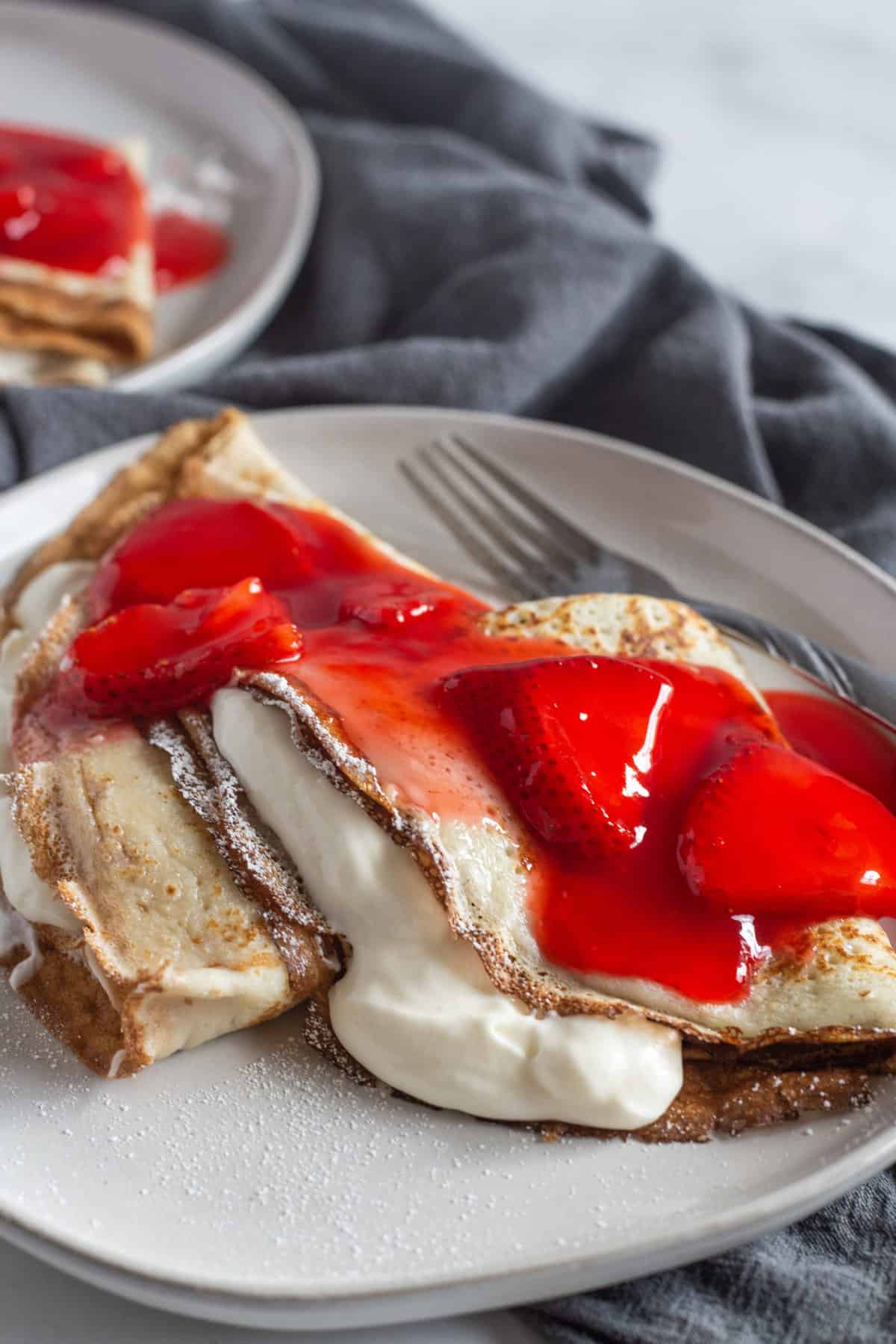 Strawberry crepes on a white plate.