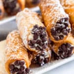 A stack of homemade cannoli on a white plate.