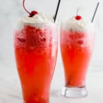 Two glass with italian cream soda on a marble surface.