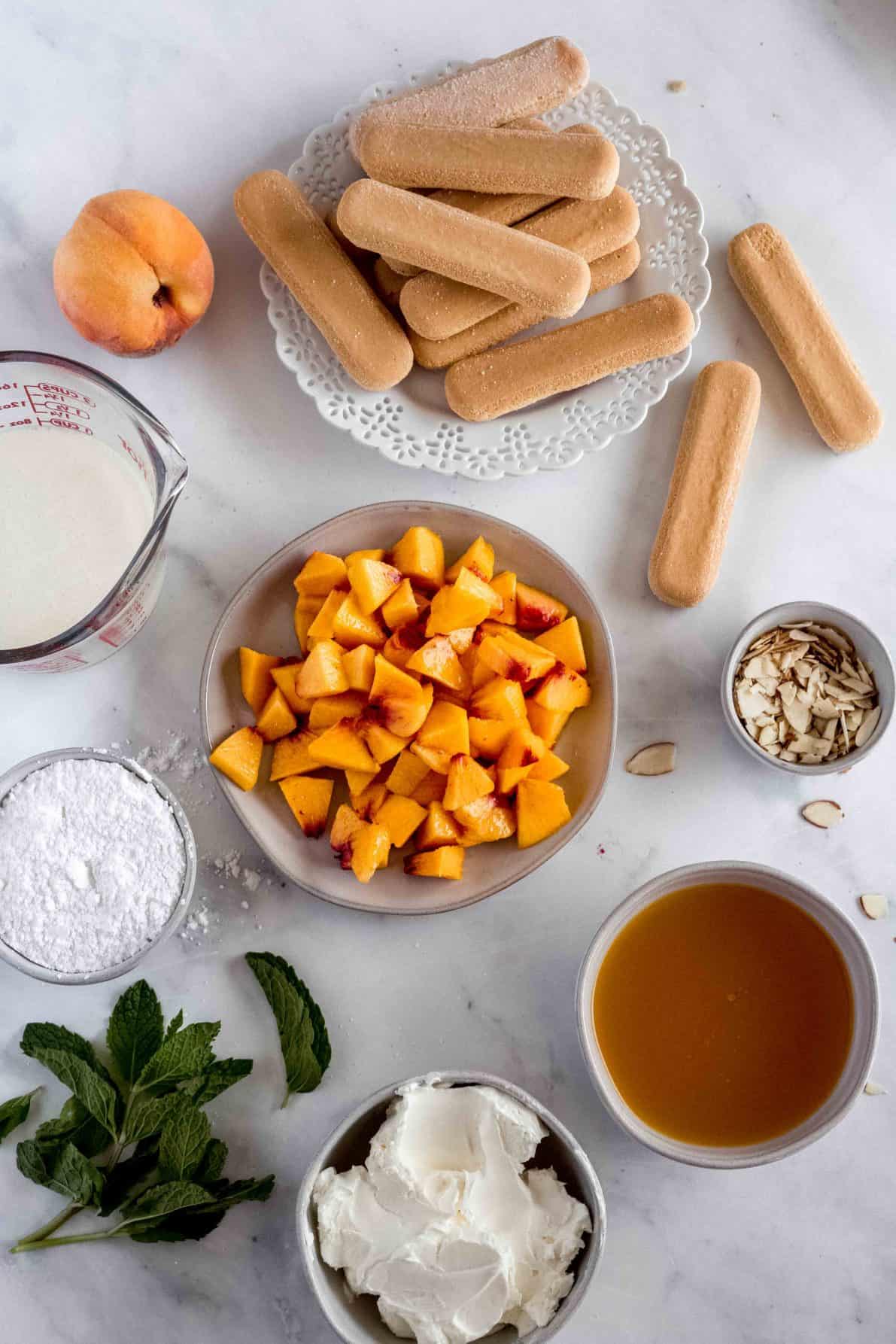 Ingredients for Easy Peach Tiramisu laid on a marble surface.