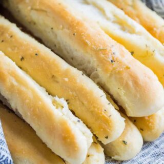 A pile of garlic butter breadsticks wrapped in a towel.