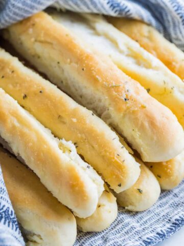 A pile of garlic butter breadsticks wrapped in a towel.