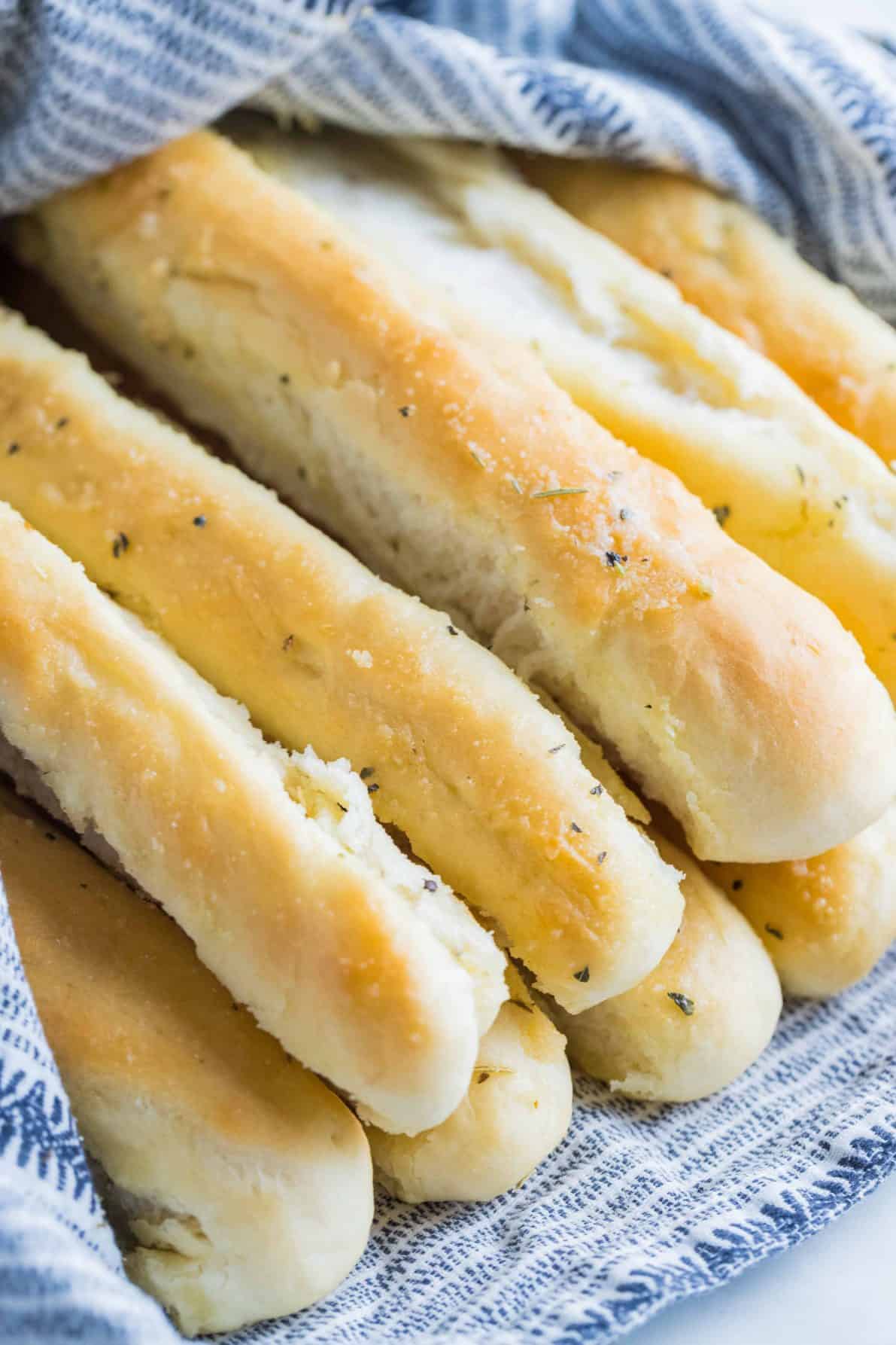 A pile of garlic butter breadsticks wrapped in a towel.