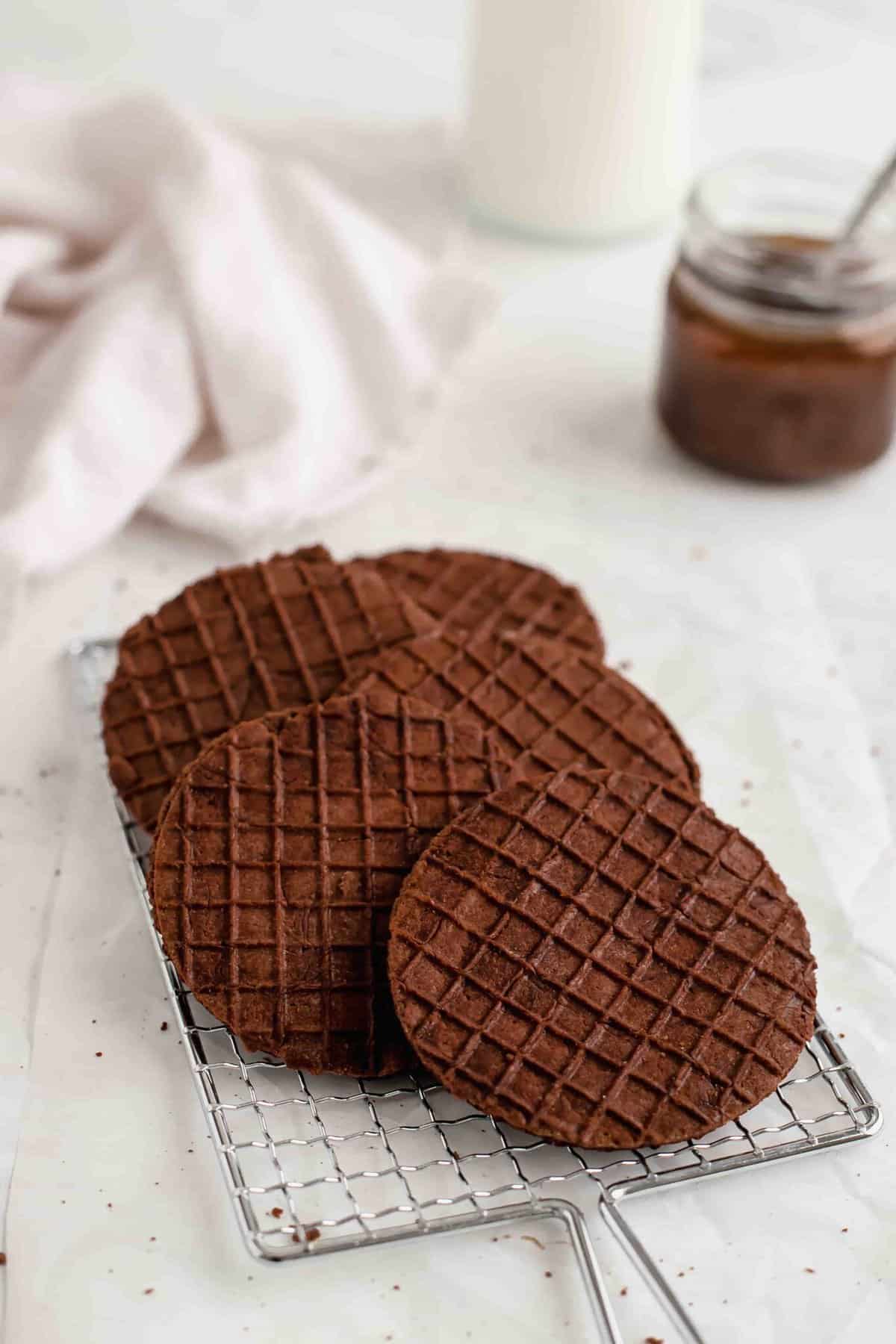 Chocolate stroopwafels laid on a wire rack.