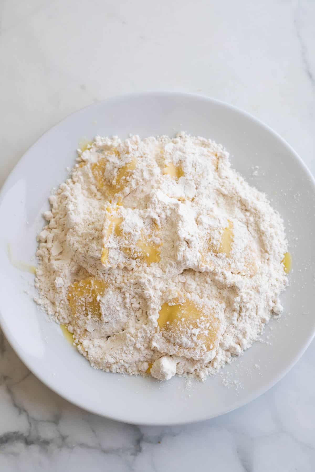 A plate of ravioli coated in flour.