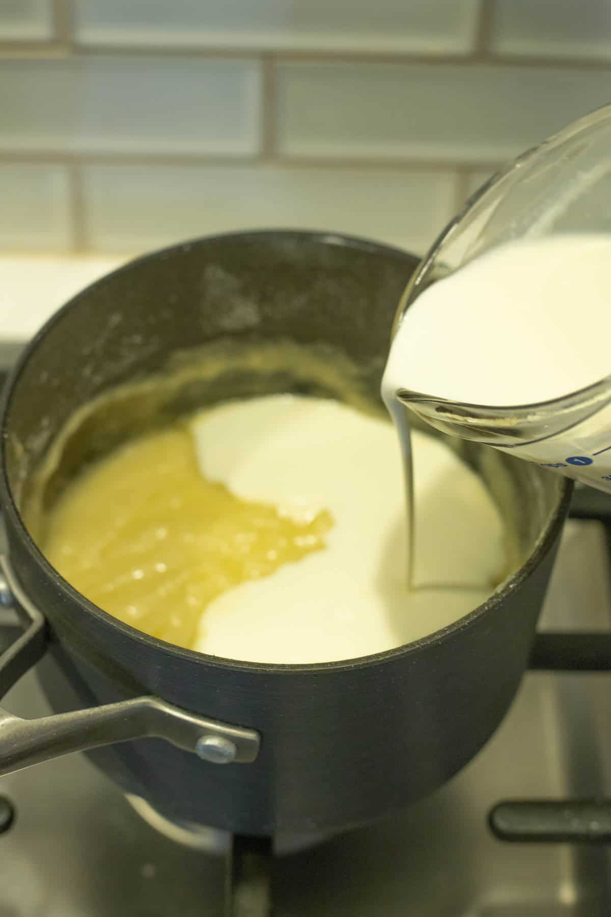 Cream being poured into saucepan.