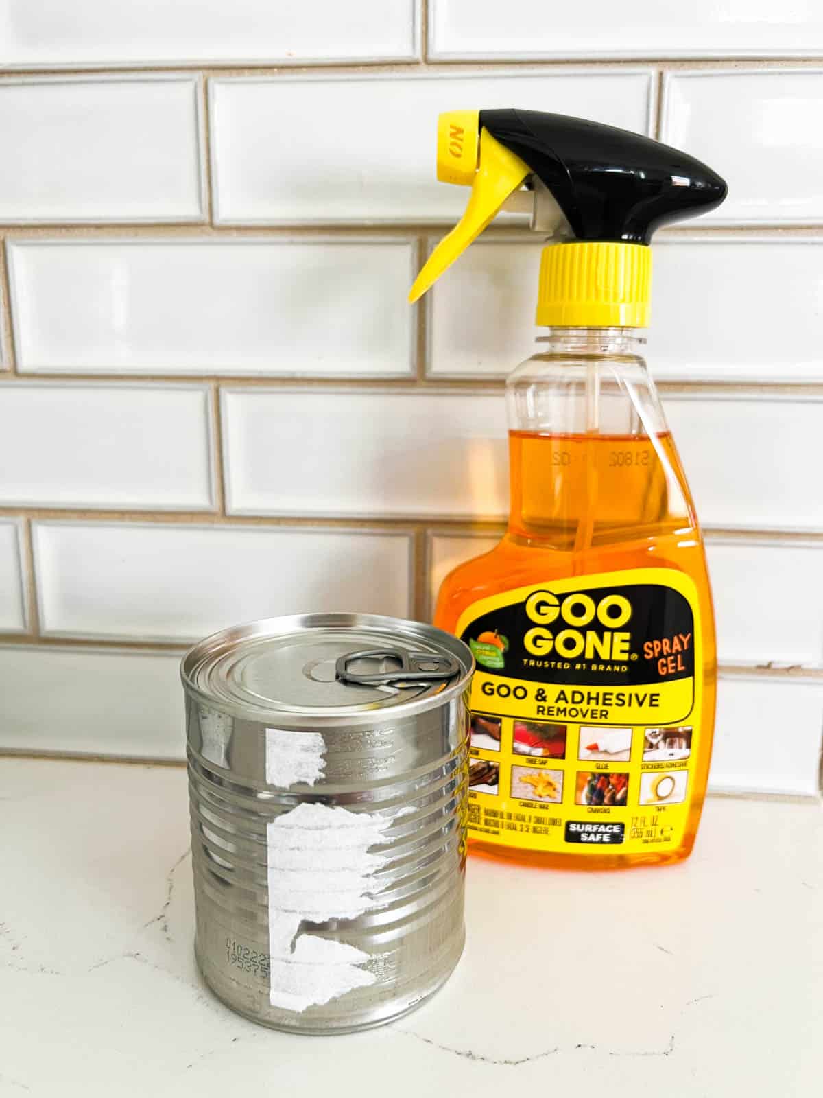 A can with a bottle of Goo Gone sitting next to it.