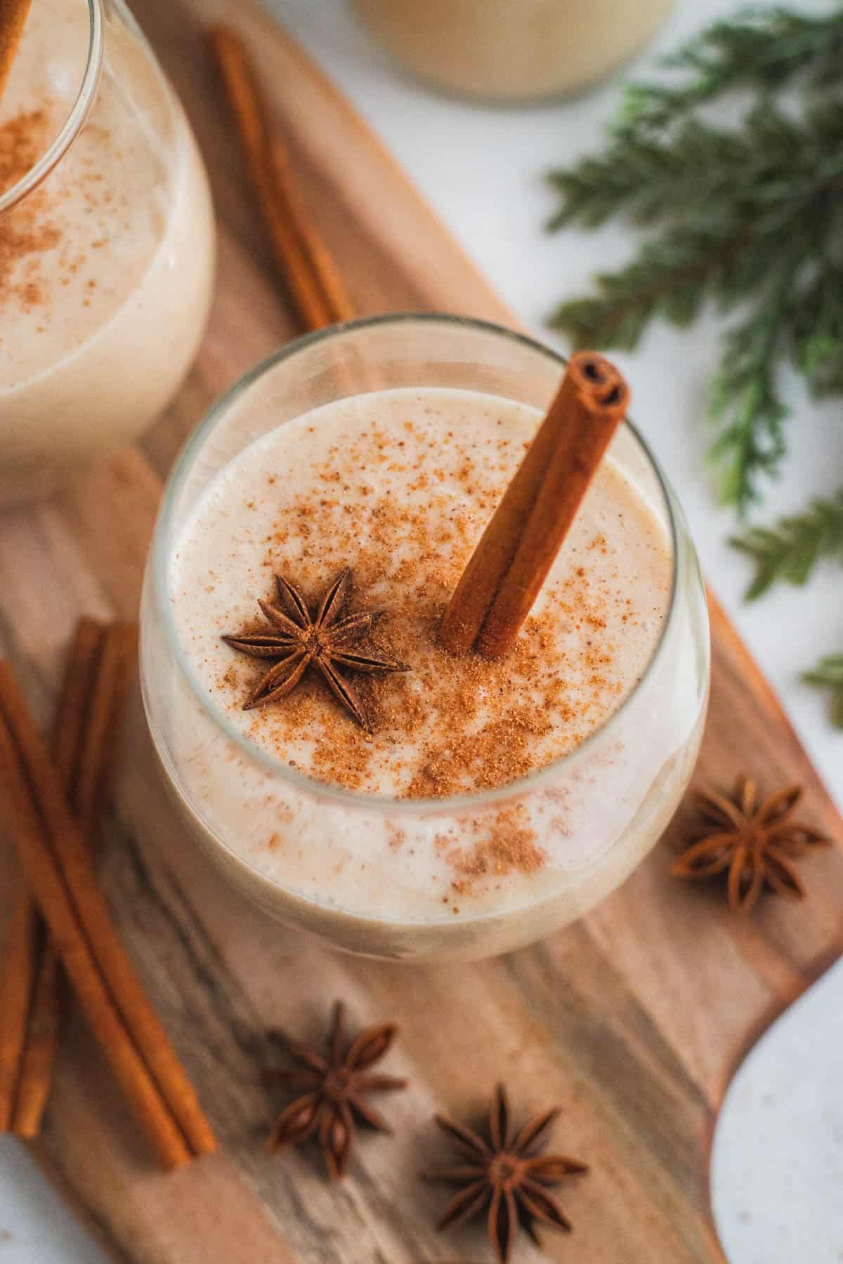 A glass of coquito on a wooden surface.