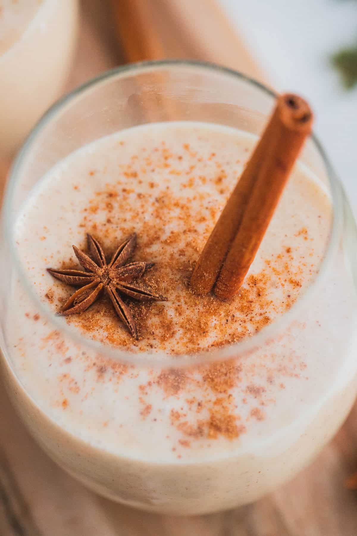 Coquito topped with star anise and cinnamon stick.