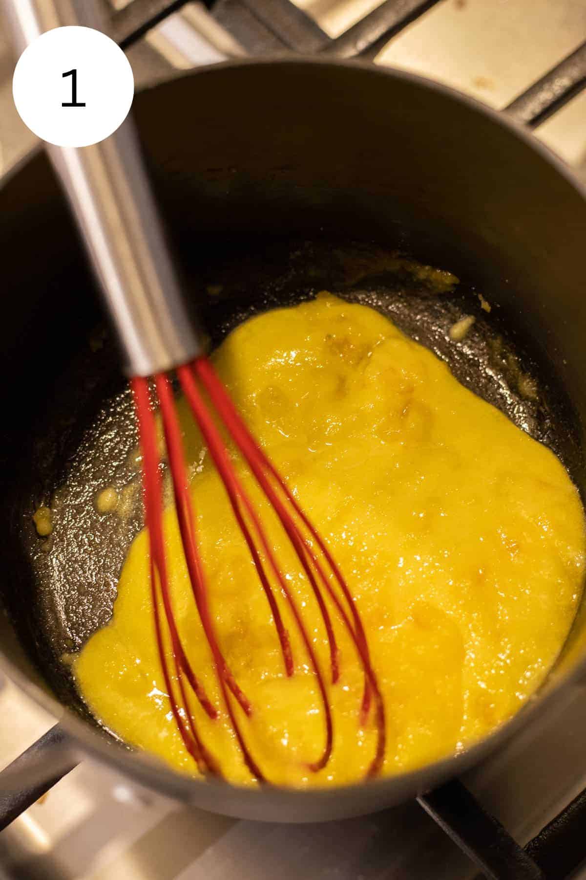 Whisking egg yolks and sugar in a sauce pan.
