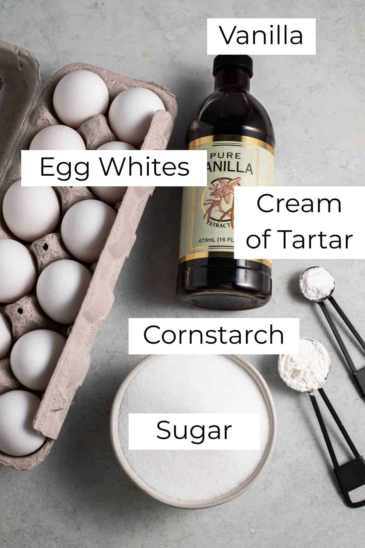 Labeled ingredients for pavlova on a gray surface.