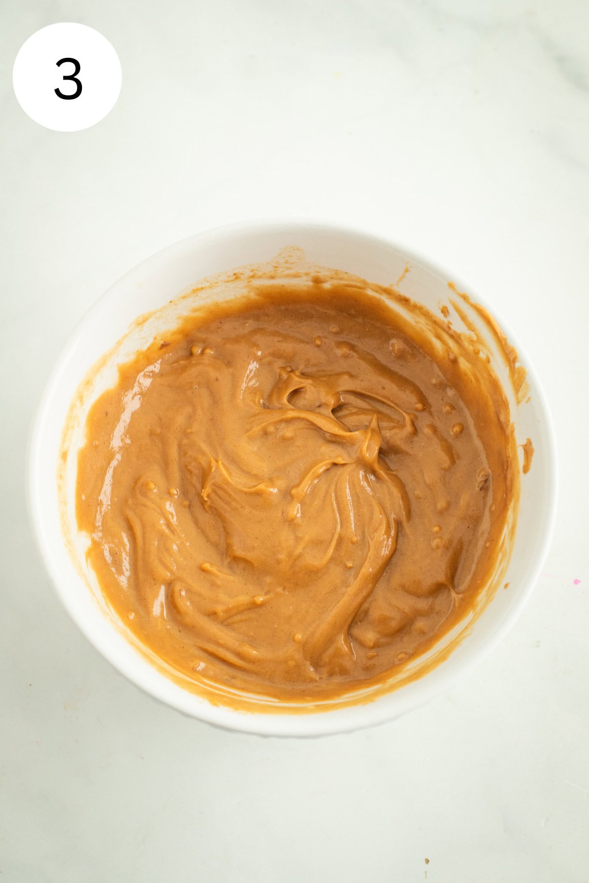 Whisked peanut sauce in a bowl.
