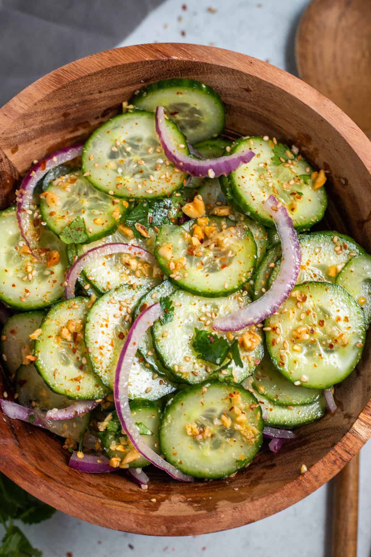 A wood bowl with Thai cucumber salad in it.