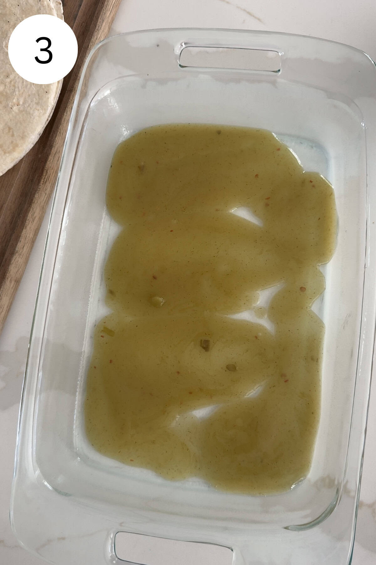 Enchilada sauce in a glass baking pan.