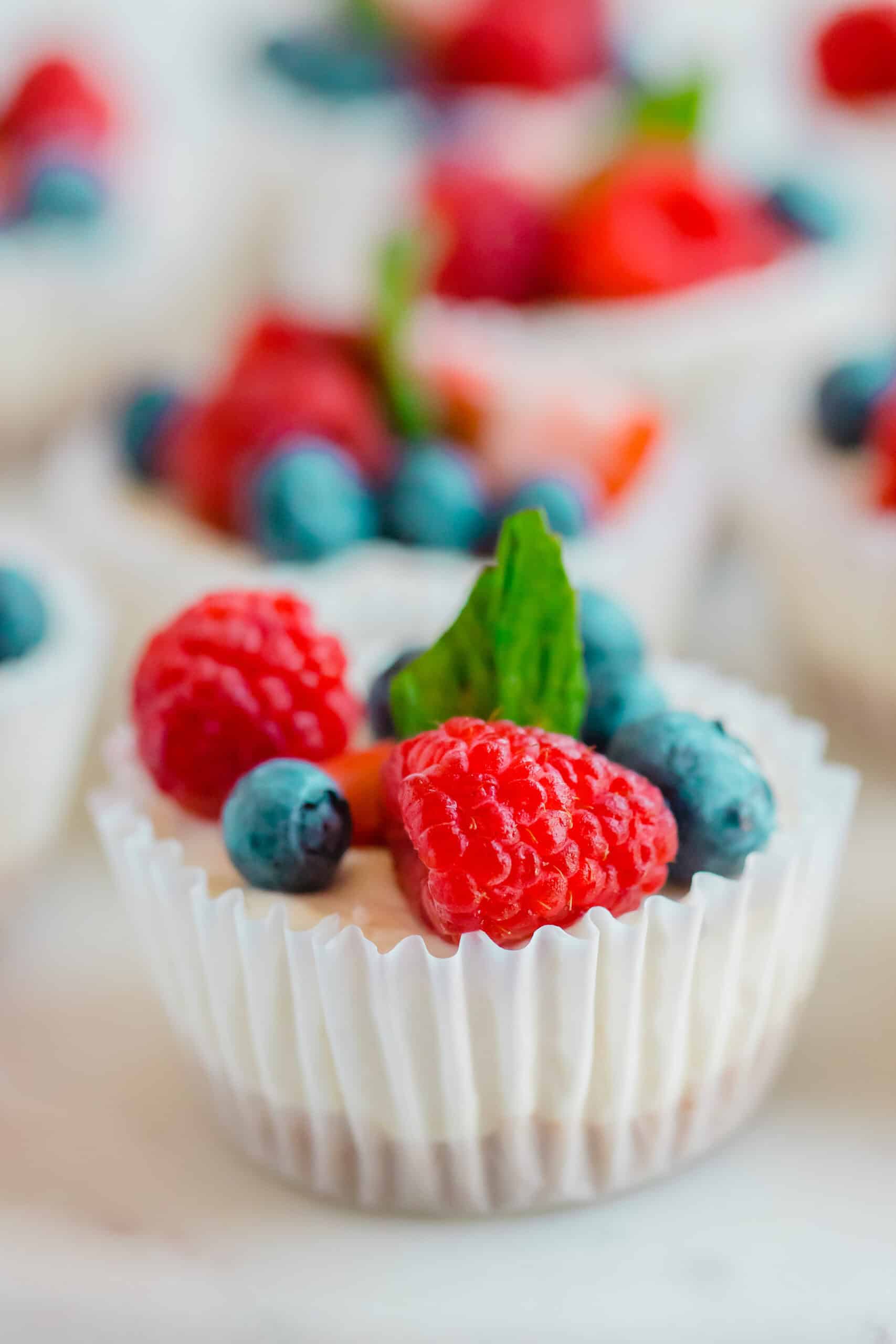 A no-bake mini cheesecake topped with fresh berries and mint.