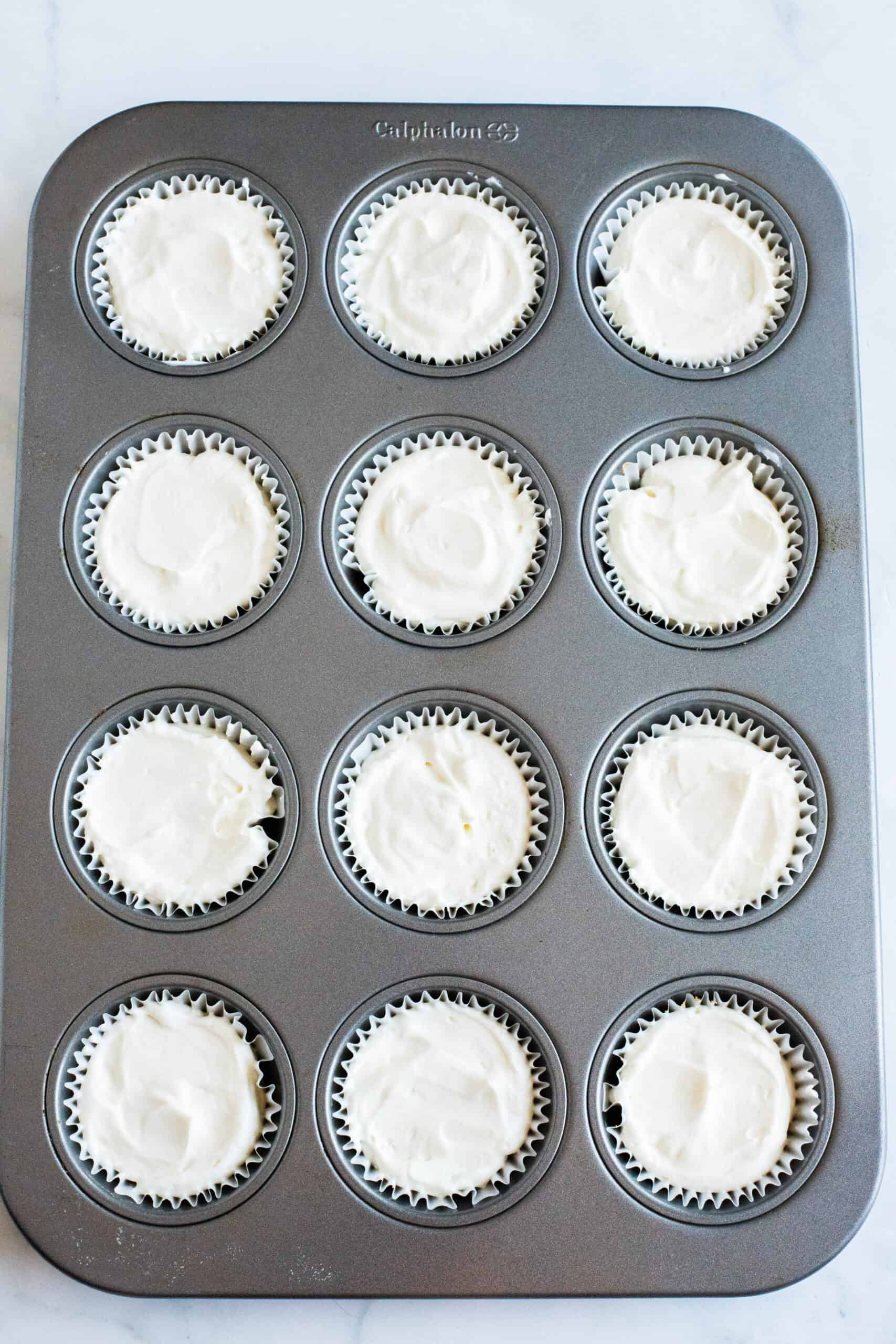 Muffin tin filled with cheesecakes.
