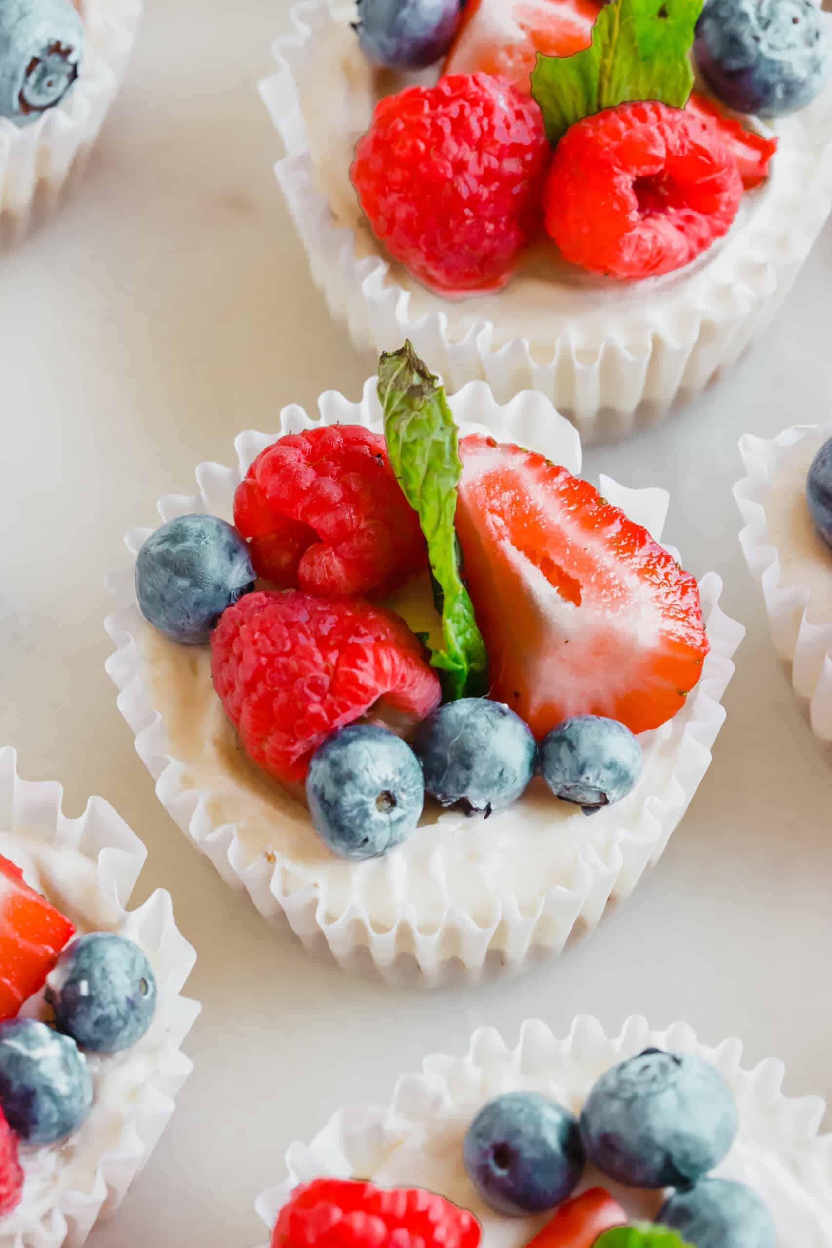 A no-bake mini cheesecake topped with berries and mint.