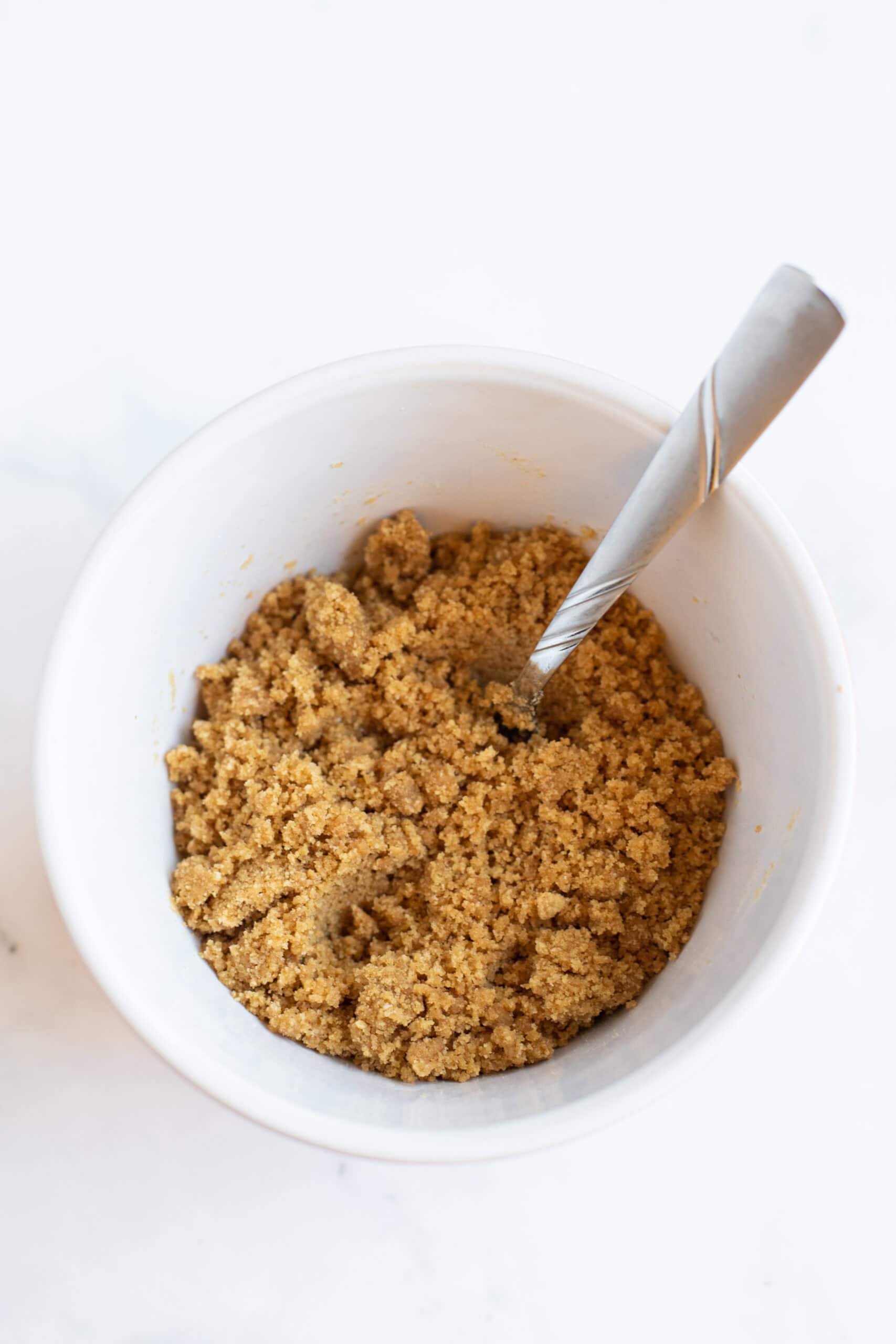 A mixing bowl with the graham cracker crust ingredients.