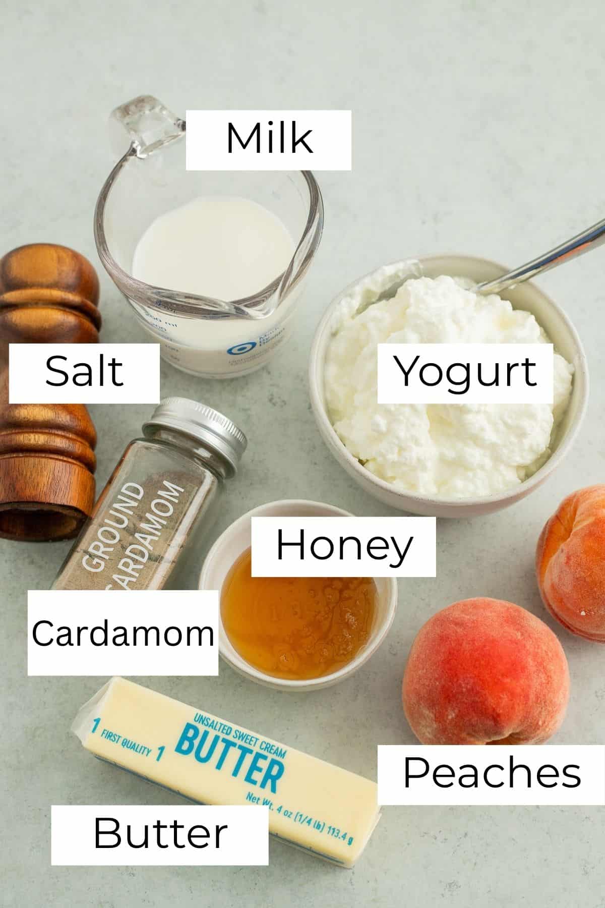 Ingredients laid out on a marble surface for peach lassi.