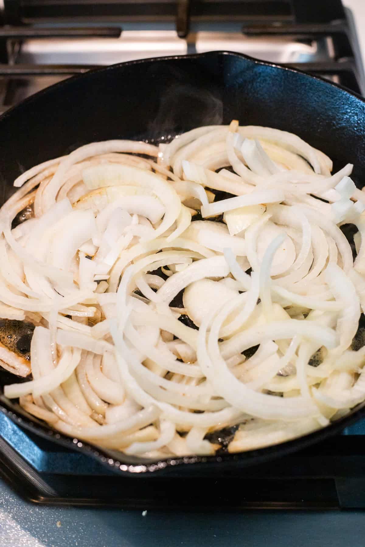 Sliced onions in a cast iron skillet.
