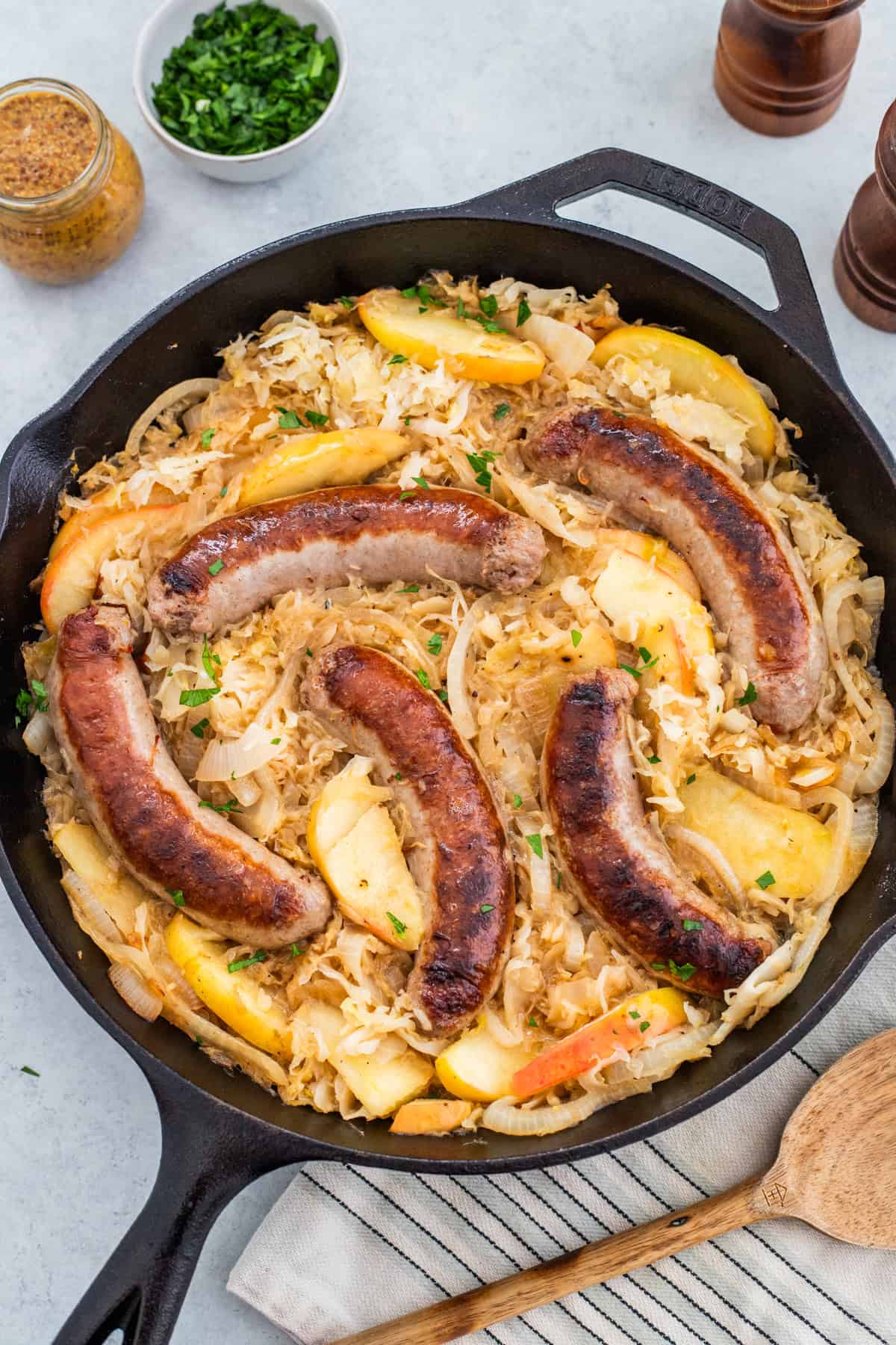 Bratwurst and sauerkraut in a cast iron skillet.