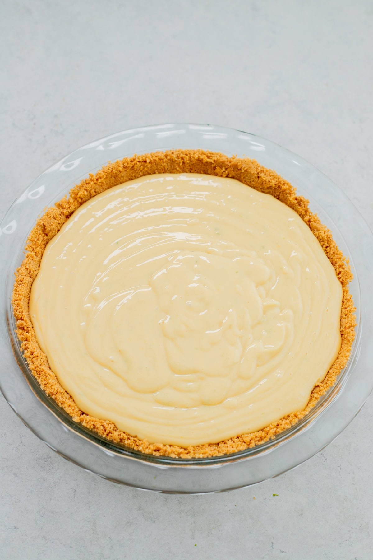 Key lime filling poured into cooled graham cracker pie crust.