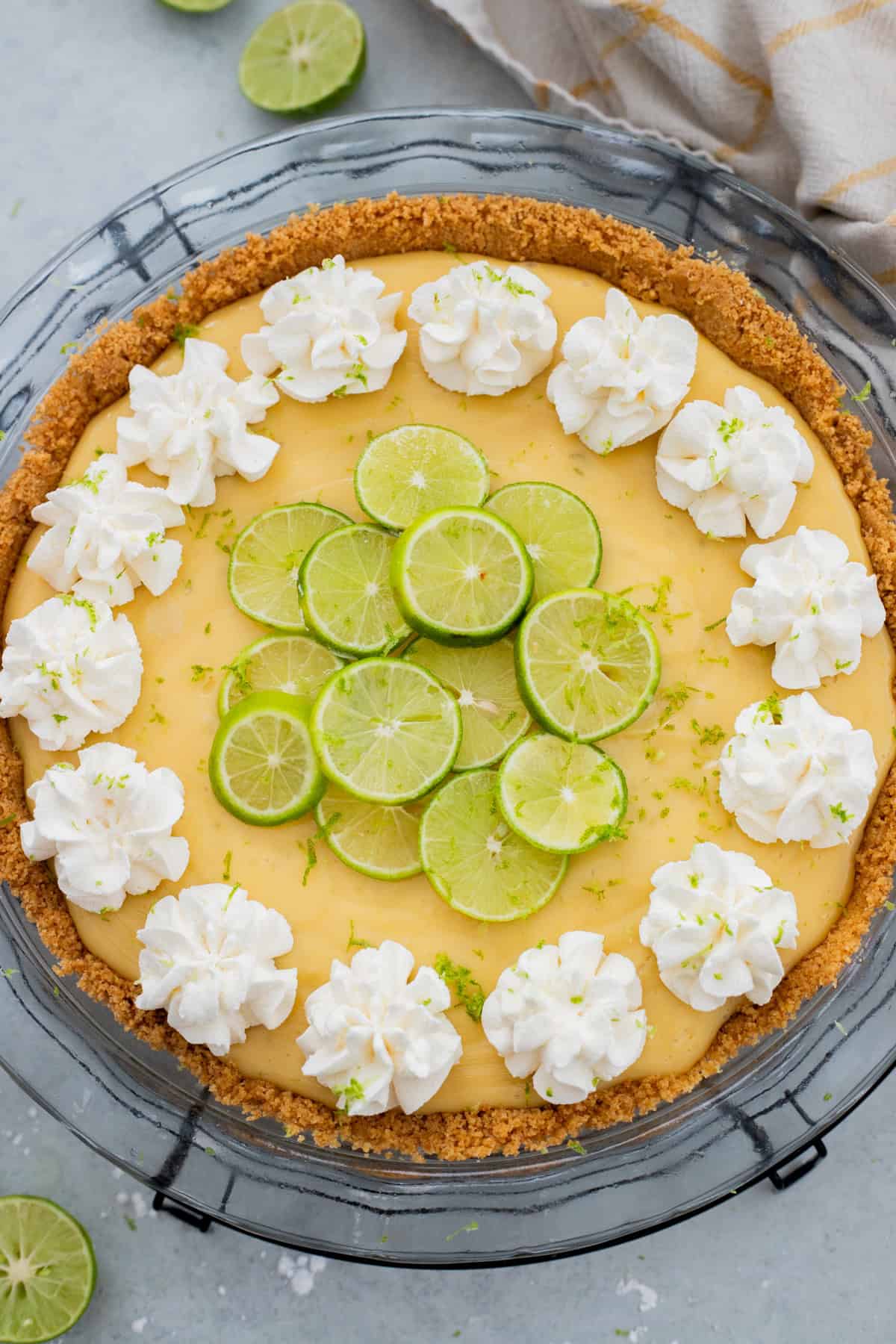 Key lime pie garnished with whipped cream and lime slices.