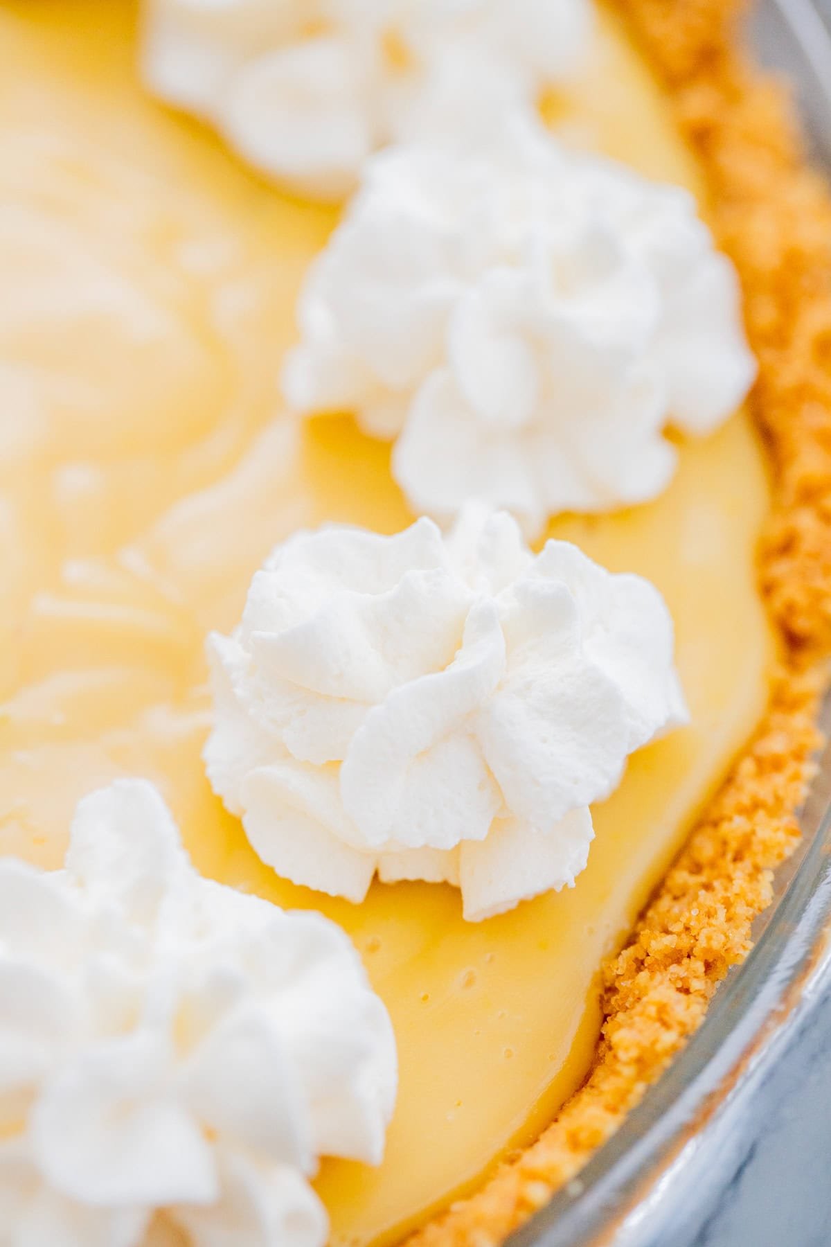 Key lime pie with whipped cream piped on top.