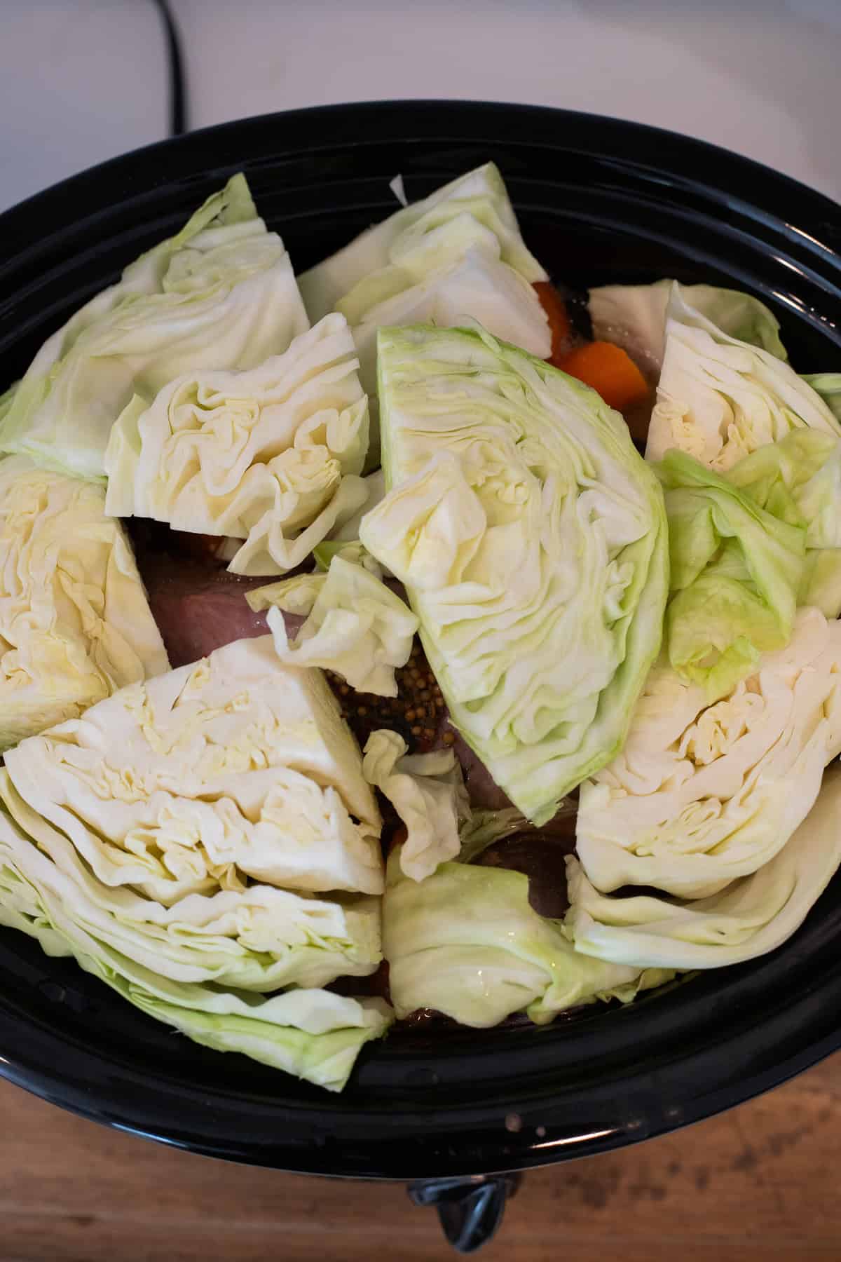 Cabbage wedges added to crockpot.